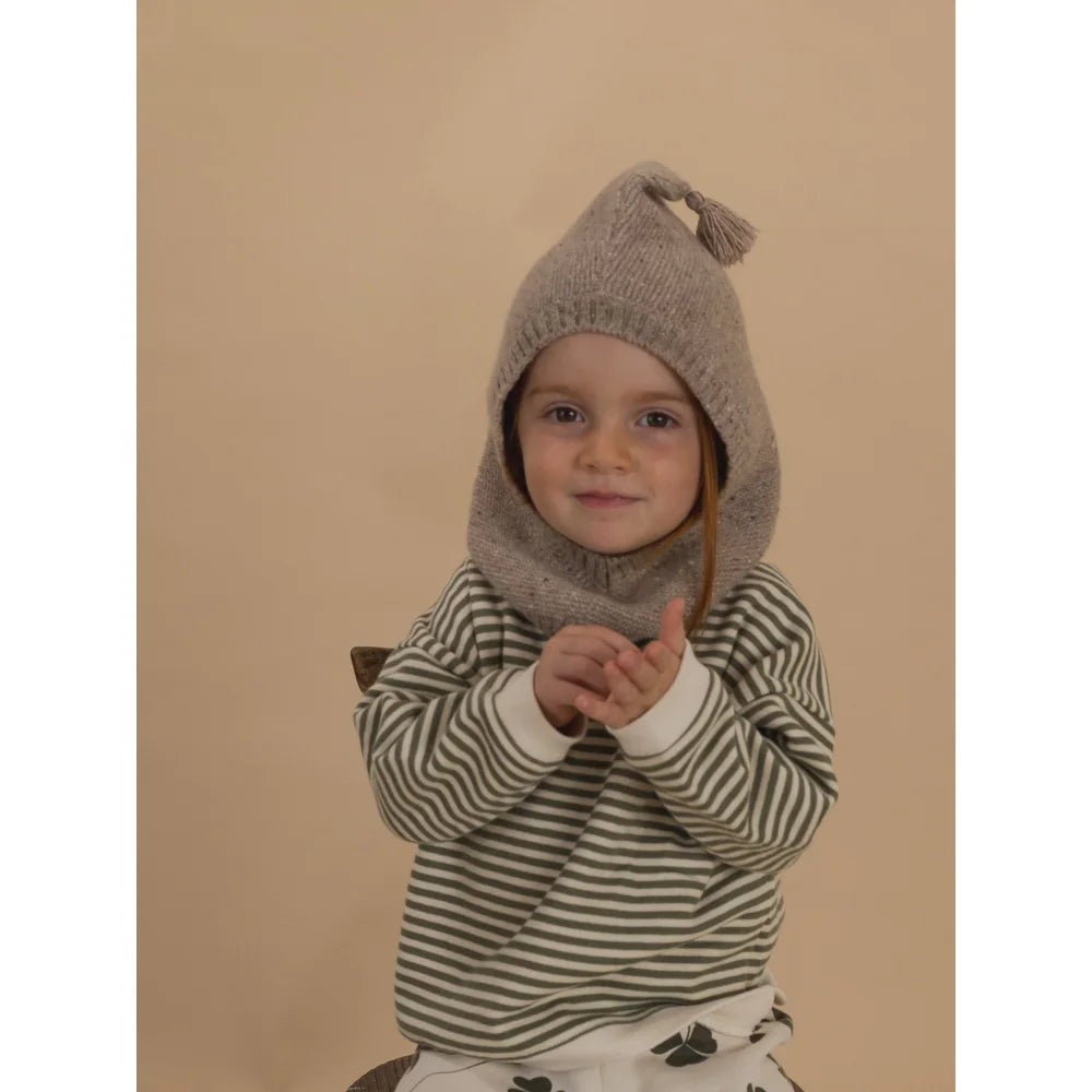 Junge trägt Wollbalaklava in Oatmeal mit Spitze und Quaste, grün-weiß gestreift