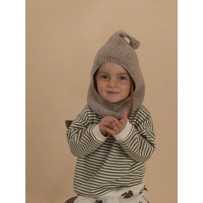 Junge trägt Wollbalaklava in Oatmeal mit Spitze und Quaste, grün-weiß gestreift