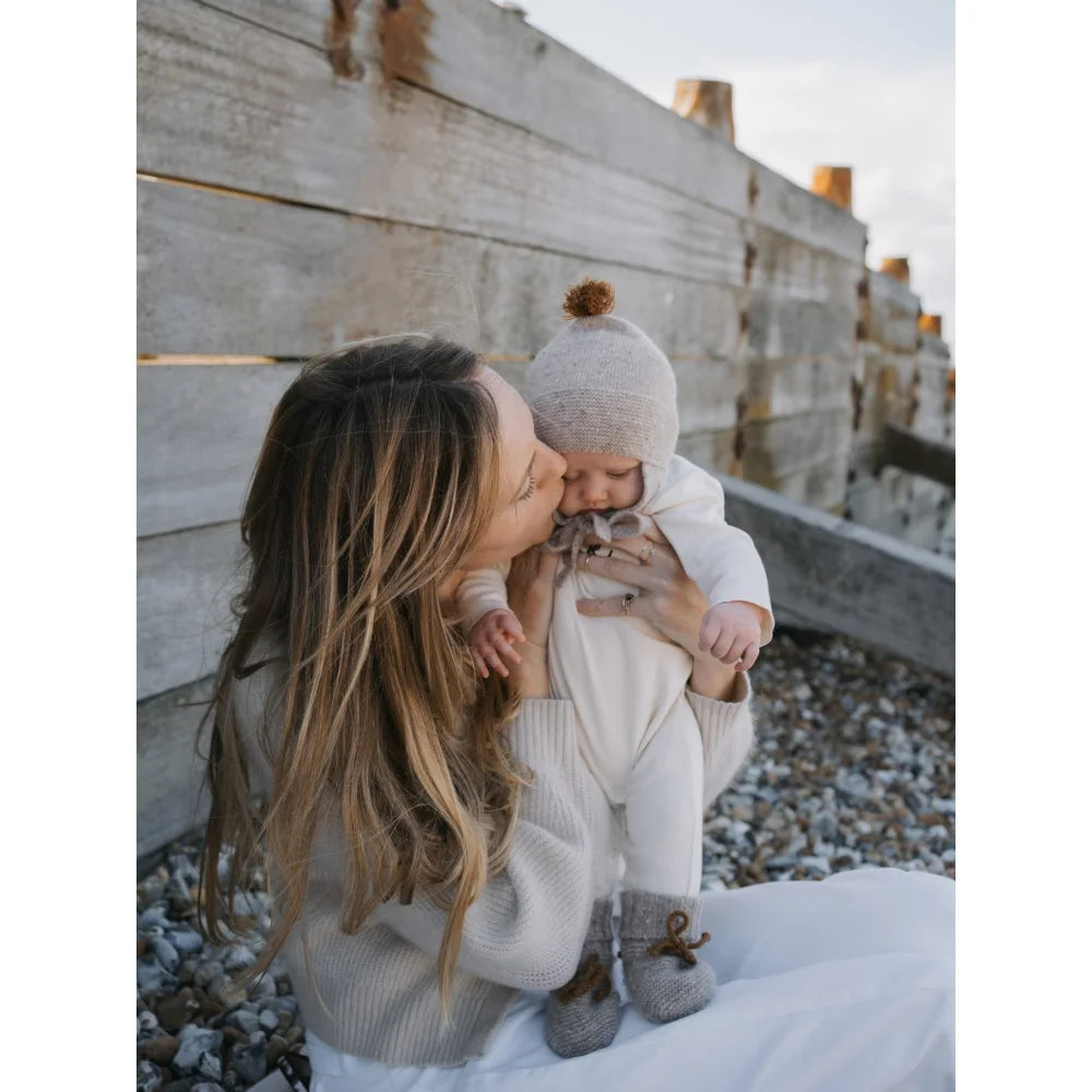 Mama küsst Baby in gemütlichen neutralen Wool Booties Oatmeal, super süßes Bild