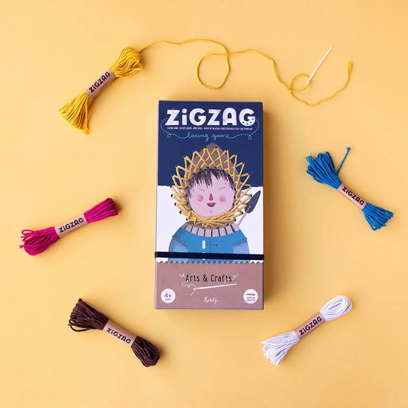 Zig Zag Spielbox mit bunter Stickgarn und Nadel drumherum