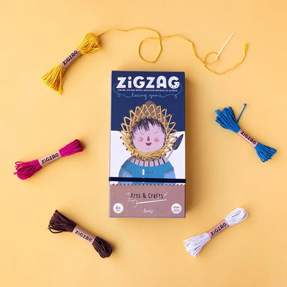 Zig Zag Spielbox mit bunter Stickgarn und Nadel drumherum